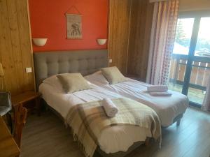 a bedroom with two beds and a large window at Hotel Le Concorde in Morzine