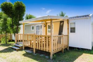 una casa pequeña con porche y techo en Camping La Pointe Saint-Gildas - Maeva, en Préfailles