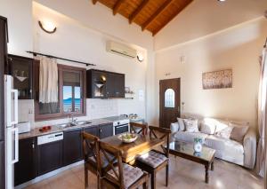 een keuken en woonkamer met een tafel en een bank bij Yasemi by Vintage Travel in Sivota