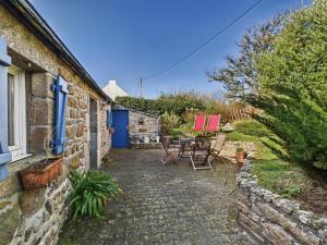 a patio with a table and chairs outside of a house at Charmante maison en pierre - vue sur l'océan in Lilia