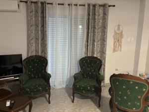 two chairs and a television in a living room at Rosi Rhodos in Rhodes Town +3 photos
