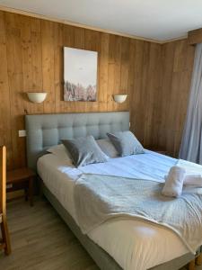 una camera da letto con un grande letto e pareti in legno di Hotel Le Concorde a Morzine Altre 94 foto