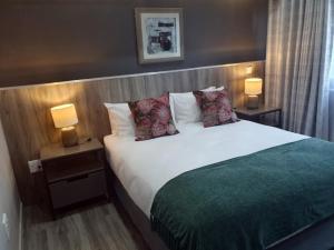 a bed in a hotel room with two lamps at La Orchard Hotel in Johannesburg