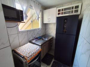 a small kitchen with a sink and a refrigerator at Acomodação São José dos pinhais in São José dos Pinhais