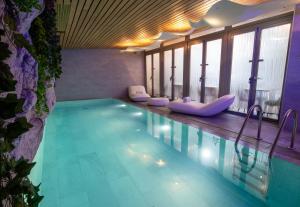 a pool in a hotel with purple chairs and windows at Hôtel B55 in Paris