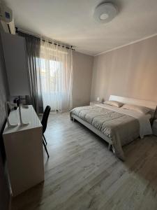 een slaapkamer met een bed, een bureau en een raam bij Favoloso trilocale in Monza +6 foto's