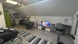 a living room with a couch and a tv and a table at Futrinka Vendégház in Baja