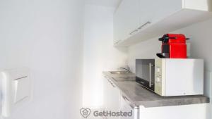 a kitchen with a red appliance on a counter at La Villette - Charming flat in Pantin - GetHosted in Pantin