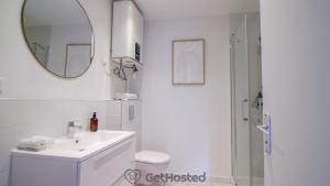 a white bathroom with a sink and a mirror at La Villette - Charming flat in Pantin - GetHosted in Pantin