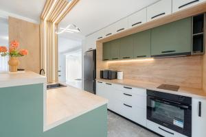una cocina con encimeras blancas y armarios verdes en Pensiunea Agroturistică Victoria Mărișel, en Mărişel 29 fotos más
