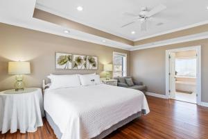 ein Schlafzimmer mit einem Bett und einem Deckenventilator in der Unterkunft Above The Waves House in Fort Morgan + 40 Fotos