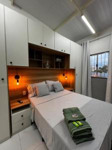 a bedroom with a large bed with a wooden headboard at Loft Oriente - 800m do Parque das Águas in São Lourenço
