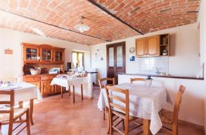 cocina y comedor con mesas y sillas en Bed and Breakfast Val d'Oche, en Castel Boglione