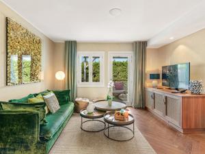a living room with a green couch and a table at Boho Club in Marbella