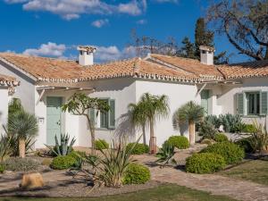 a white house with palm trees and plants at Boho Club in Marbella