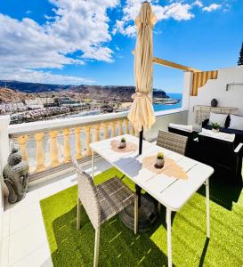 a white table and chairs on a balcony with a view at Atlantic Ocean & Beach Views - Playa Del Cura in Las Palmas de Gran Canaria