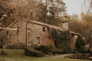 an old stone house with ivy growing on it at Casas Alexandre in Pontevedra