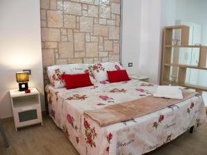 a bedroom with a large bed with red pillows at Donsanto Casa Vacanze in Taormina