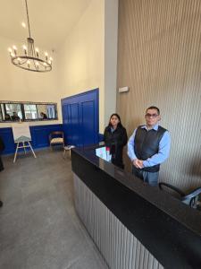 a man and a woman standing at a counter at Acogedor Departamento en Cusco, Ideal para Familias y Amigos, Equipado y Céntrico in Cusco