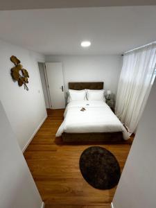una camera da letto con un letto con lenzuola bianche e un tappeto di Amadora Flat 1 ad Amadora