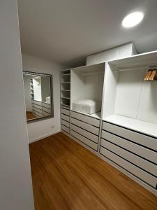 una stanza vuota con scaffali bianchi e uno specchio di Amadora Flat 1 ad Amadora