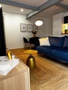 un soggiorno con un divano blu e un tavolo di Amadora Flat 1 ad Amadora