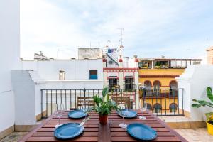 einen Holztisch mit blauen Platten auf dem Balkon in der Unterkunft casa feria in Sevilla