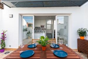 einen Esstisch mit blauen Tellern und Gläsern in der Unterkunft casa feria in Sevilla