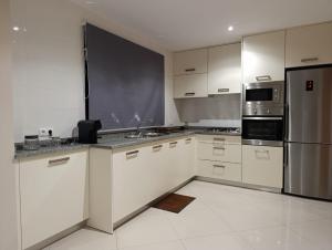 a kitchen with white cabinets and stainless steel appliances at Elly Apartamentos in Mindelo