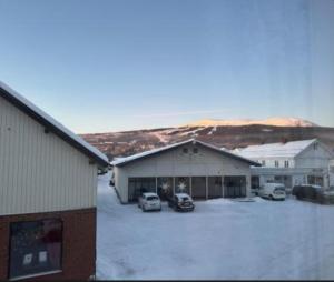 a group of buildings with cars parked in a parking lot at Trysil sentrum leilighet in Trysil