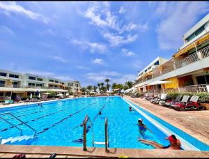 ein Pool in einem Resort mit Menschen darin in der Unterkunft Duplex at Solemar resort, totally renovated, pools, tennis, basketball, football in Al Kaslīk