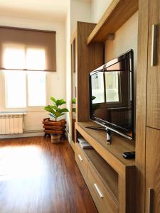 a living room with a flat screen tv on a entertainment center at Apartamento Pena Furada in Ribadeo