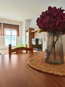 a vase of red roses sitting on top of a table at Apartamento Pena Furada in Ribadeo