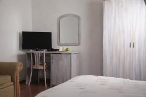 a bedroom with a desk with a television and a mirror at Tenisa klubs Jūra in Jūrmala