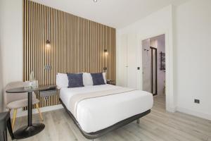 ein Schlafzimmer mit einem Bett und einem Tisch darin in der Unterkunft Dobo Madrid Lucero in Madrid