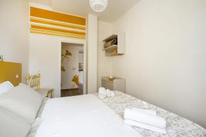 Un dormitorio con una cama blanca con dos toallas encima. en Gufo di Mare - Giallo, en Savelletri di Fasano