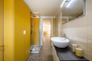 baño con lavabo blanco y pared amarilla en Gufo di Mare - Giallo, en Savelletri di Fasano 12 fotos más
