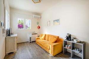 sala de estar con sofá amarillo y ventana en Gufo di Mare - Giallo, en Savelletri di Fasano