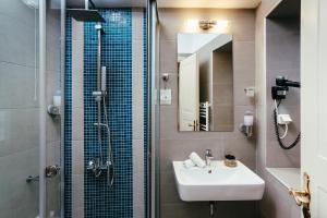 un bagno con lavandino e doccia con specchio di Hotel Kastro a Ioannina Altre 37 foto