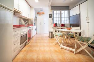 a kitchen with white cabinets and a table and chairs at Chalet adosado en la playa de Torre de la Horadada in Torre de la Horadada
