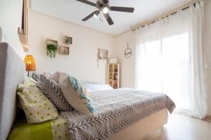 a bedroom with a bed and a ceiling fan at Chalet adosado en la playa de Torre de la Horadada in Torre de la Horadada