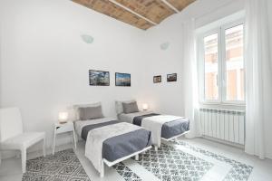 ローマにあるVatican White Domusの白い部屋で、ベッド2台、窓が備わります。