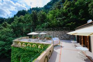 an outdoor patio with tables and chairs on a building at The Lemon Garden Villa by Elite Villas in Pontone
