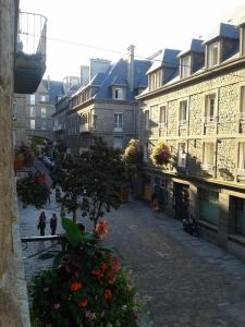 Blick auf eine Stadtstraße mit Gebäuden und Blumen in der Unterkunft Appartement Au Coeur D'intra Muros in Saint-Malo