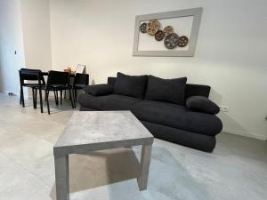 a living room with a black couch and a table at DELUXE APARTMENT (Free Parking) in Trenčín