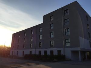 a large building with the sun setting behind it at Hotel Anna Hilden in Hilden