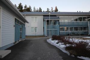 a building with a blue gate next to a driveway at MajoitusYkkönen in Raahe
