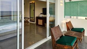 a room with two chairs and a desk and a television at The South Lake - Ahangama in Koggala