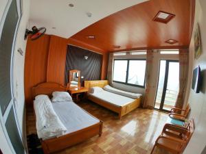 a small bedroom with two beds and a window at Minh Hưng Hostel in Sa Pa