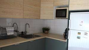 a kitchen with a sink and a white refrigerator at Retiro do Mestre in Mondim de Basto